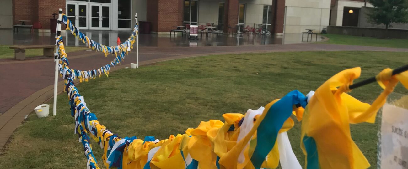 Suicide Awareness at Winthrop University of campus green is displayed through multicolored ribbon/flags.