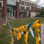 Suicide Awareness at Winthrop University of campus green is displayed through multicolored ribbon/flags.